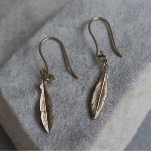 Sterling silver single feather fish hook earrings.